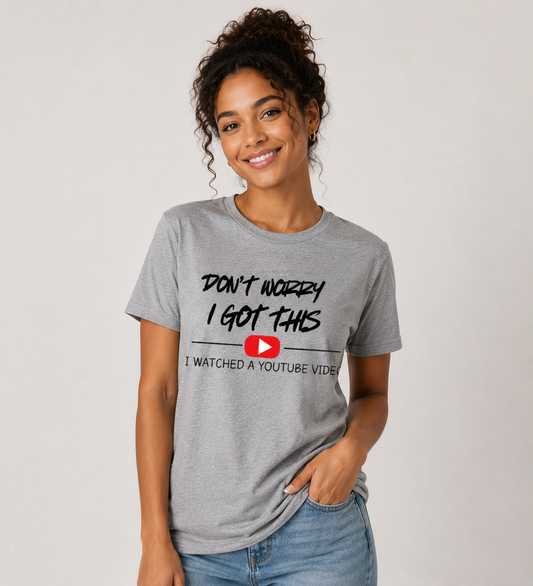 A woman wearing a gray t-shirt with a humorous text design Don't Worry I Got This I watched a Youtube Video