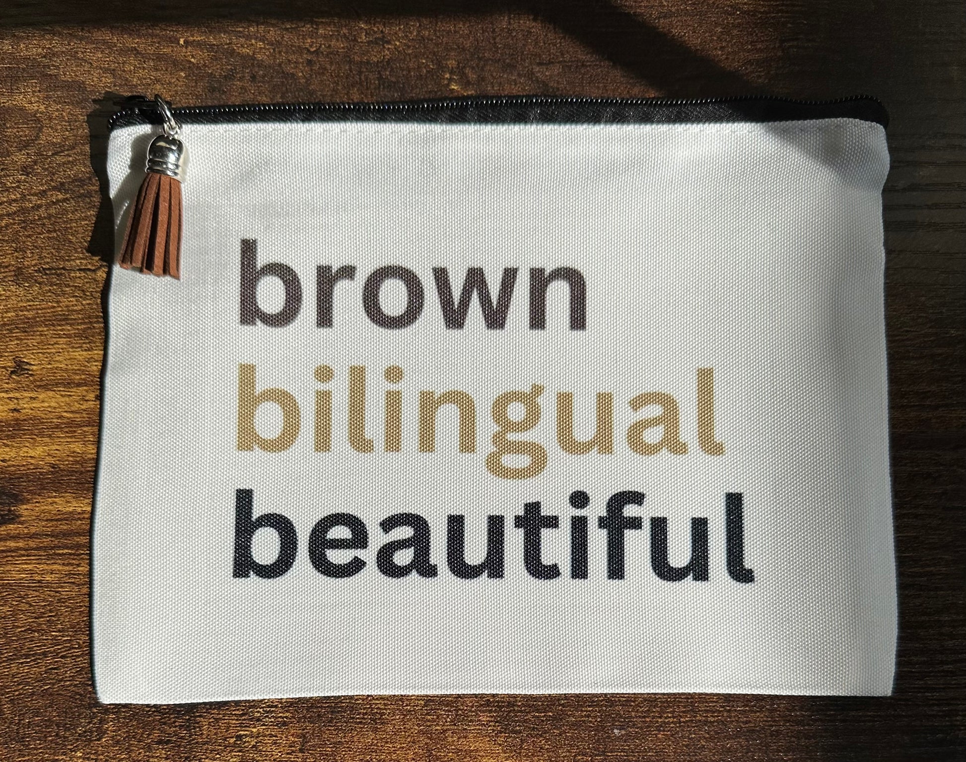 White pouch with text 'brown bilingual beautiful' 