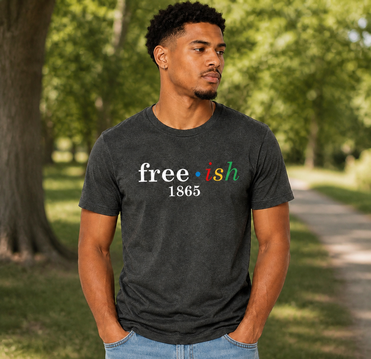 Man wearing a black t-shirt with 'free*ish 1865' text in a park.
